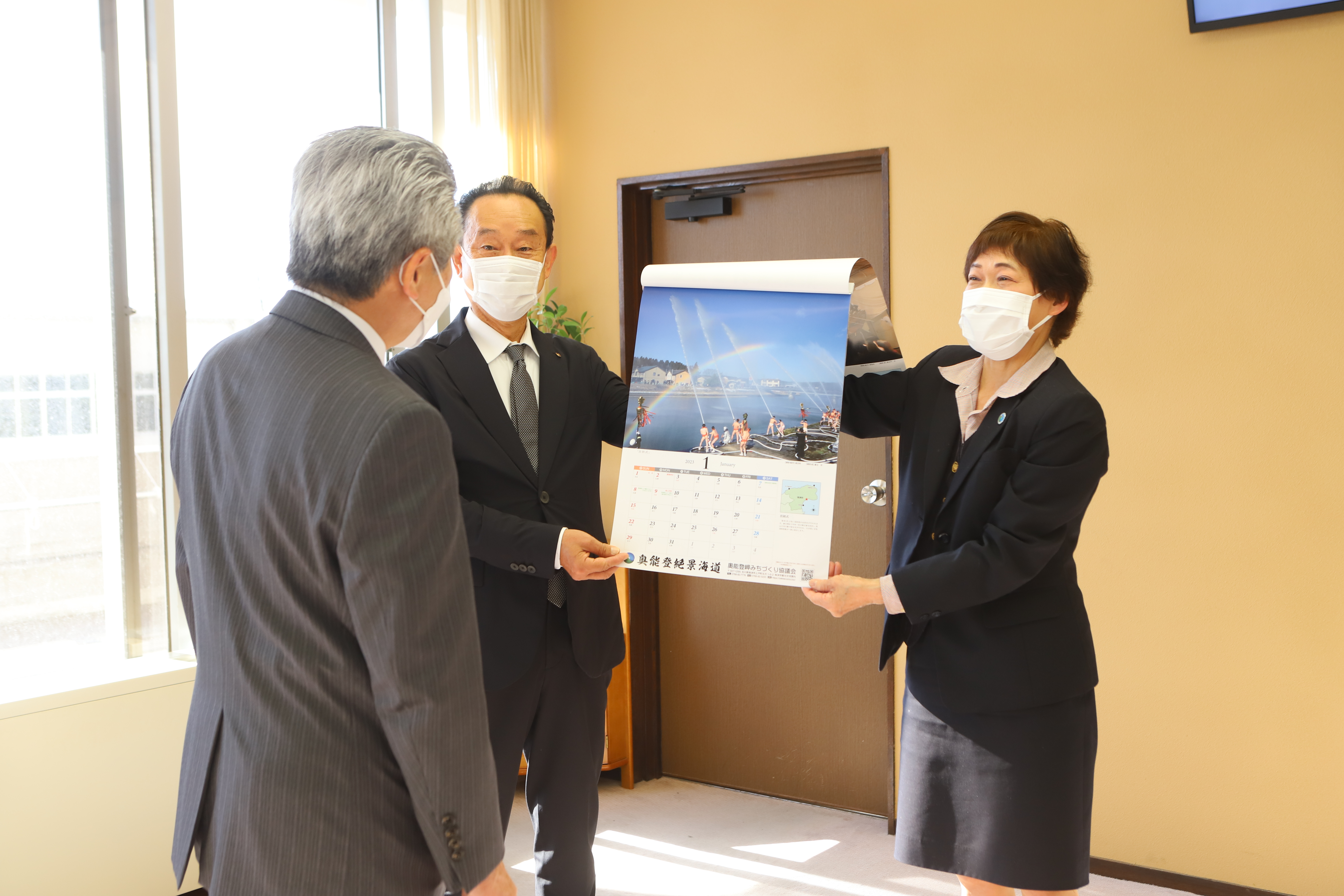 カレンダーを披露する刀祢会長と高畠副会長の画像