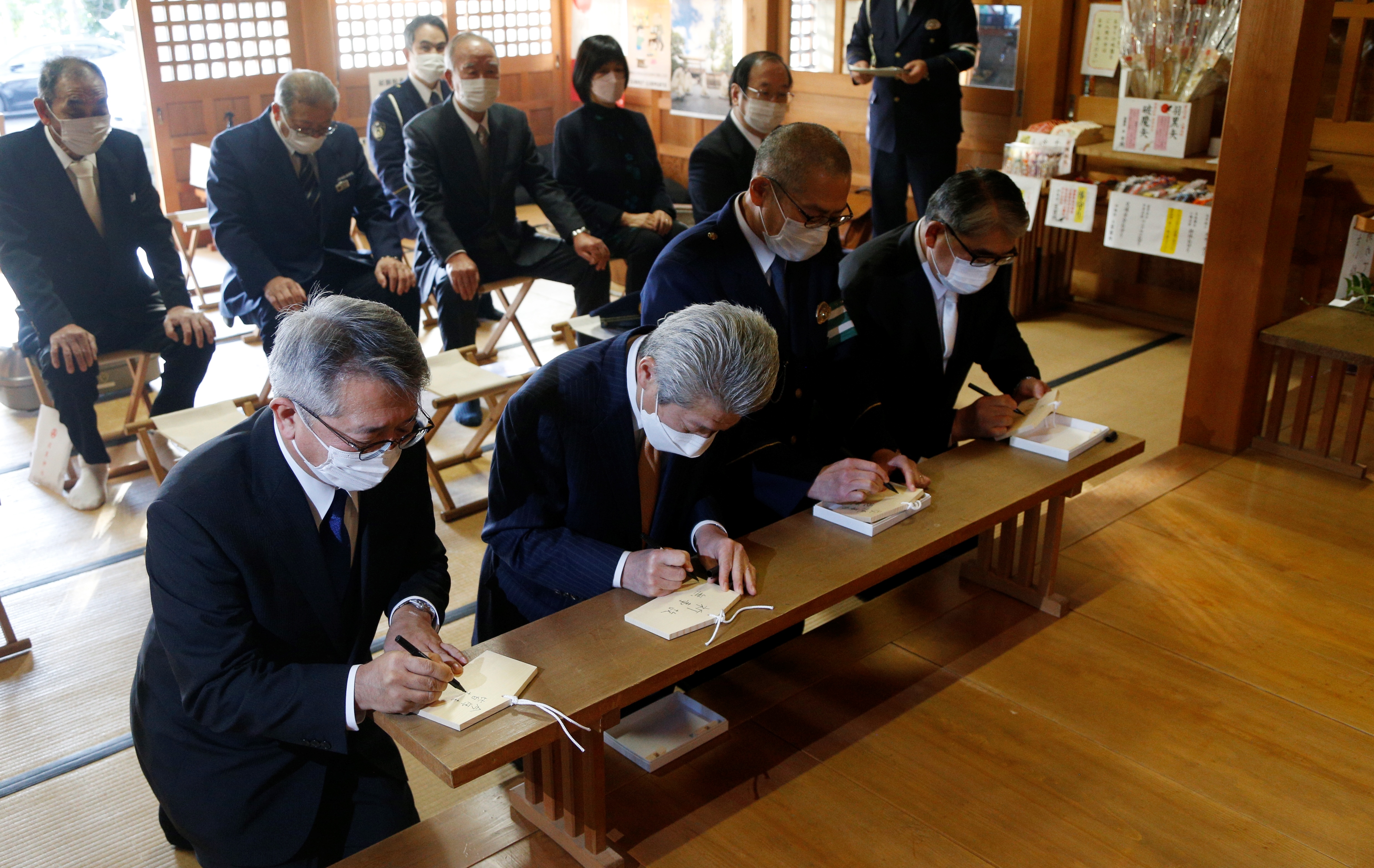 願い事を絵馬に書き込む関係者の画像