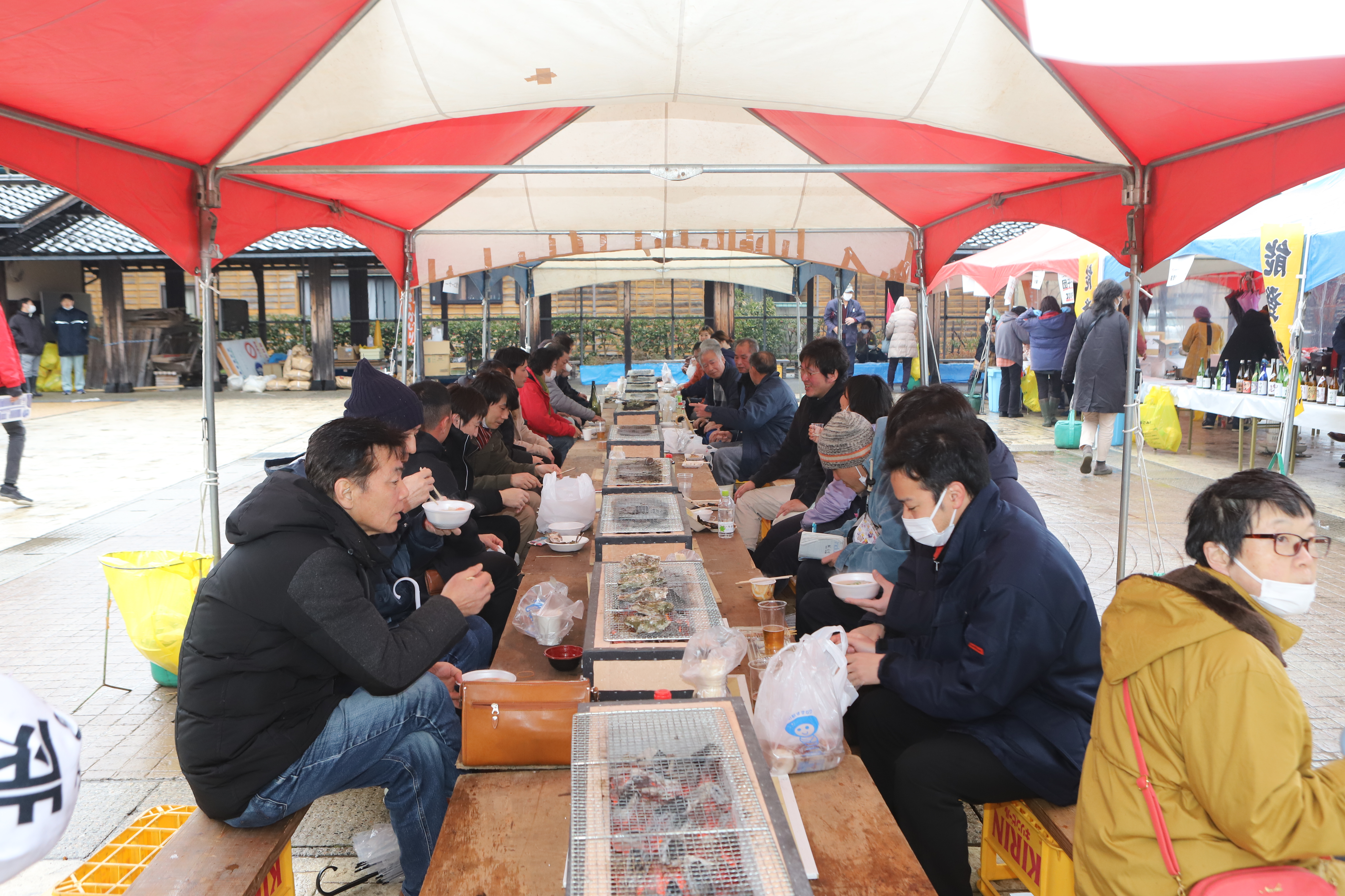 炭火焼で新鮮な海の幸を堪能する来場者の画像